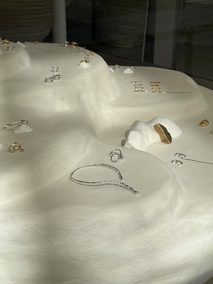 services-img Aesthetic display of gold and silver jewelry on a smooth white surface.