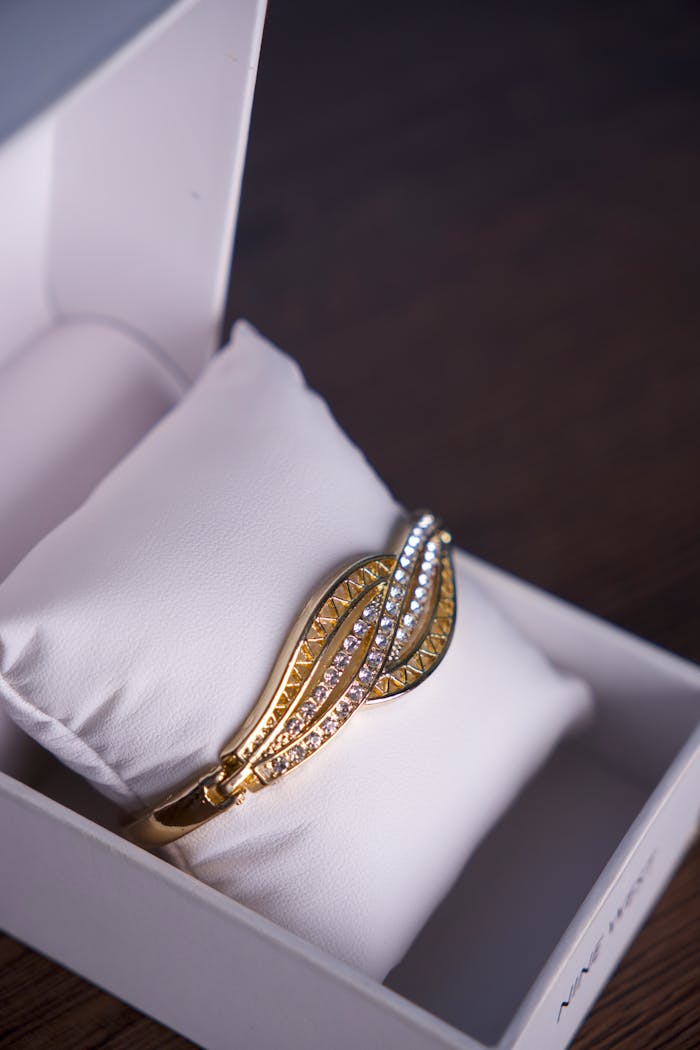 services-02 A stunning gold bracelet with diamonds elegantly presented in a white gift box, perfect for special occasions.