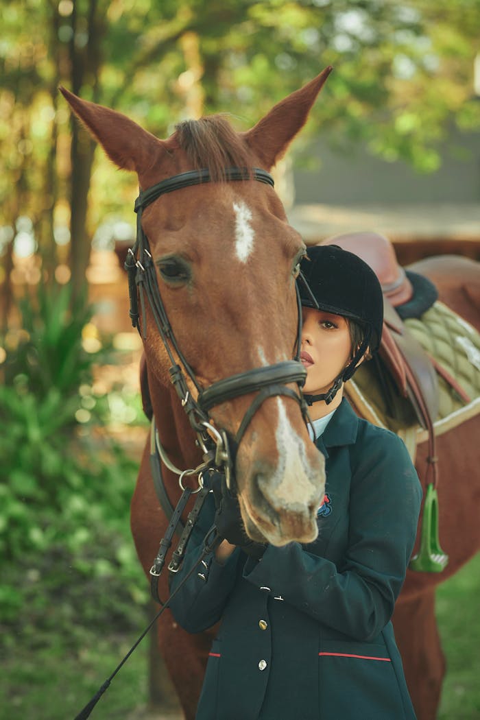 Woman in equestrian attire stands with her horse amidst greenery, showcasing companionship and sport.